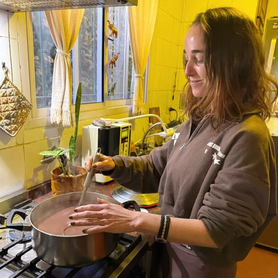 Clari García González preparando cacao ceremonial en una cocina cálida