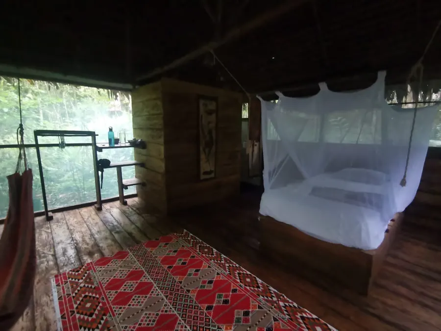 Interior de un bungalow con cama y mosquitero