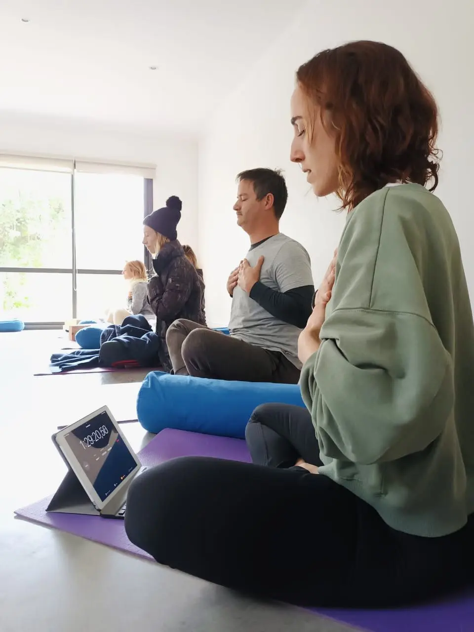 Clase de meditación presencial con la mano en el corazón