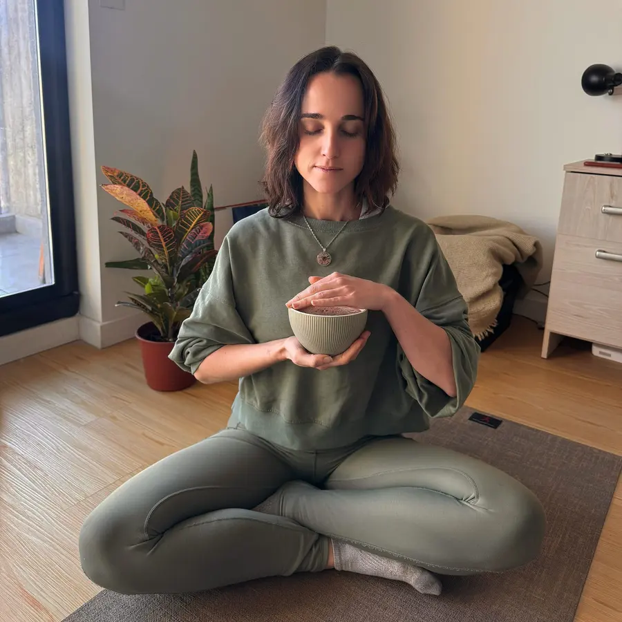 Clari García González meditando sentada con una taza de cacao entre las manos